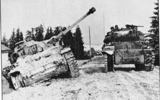 US Tanks Bataille des Ardennes - An American tank crew keeps aclose eye on aknocked-out German tank as they move towards the front line.JPG