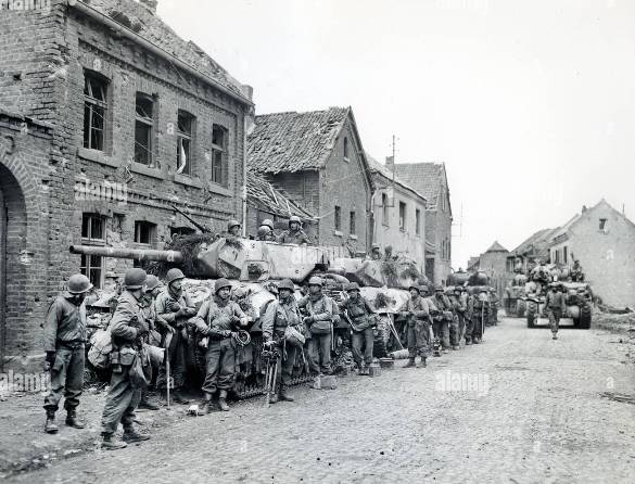 infantrymen-of-1st-division-us-first-army-resting-beside-military-tanks-monchengladbach-north-rhine-westphalia-germany-us-army-signal-corps-march-1-1945-3EM1T66.jpg